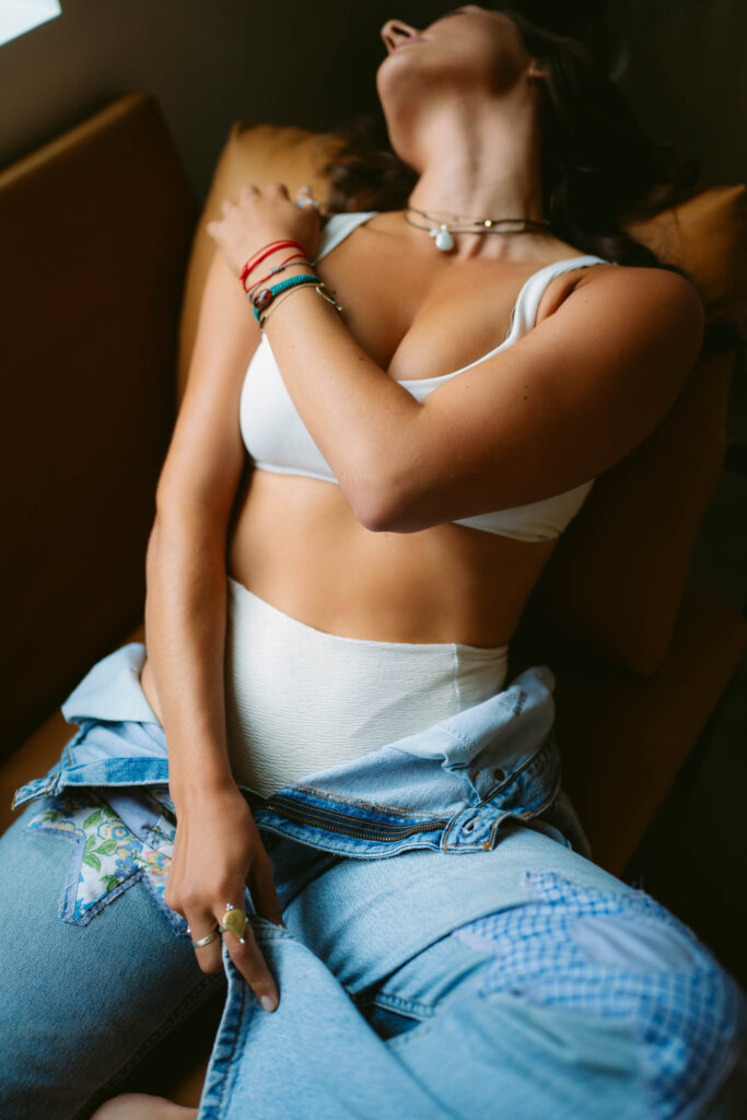 Woman relaxing in white top and blue jeans.
