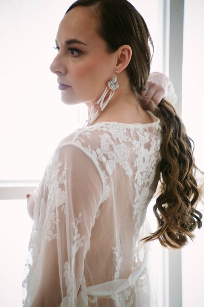Woman wearing a lace dress looking sideways.