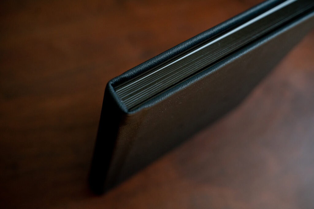 Black leather-bound book on wooden surface